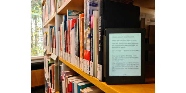 Ein Tolino-E-Reader steht in einem Bücherregal